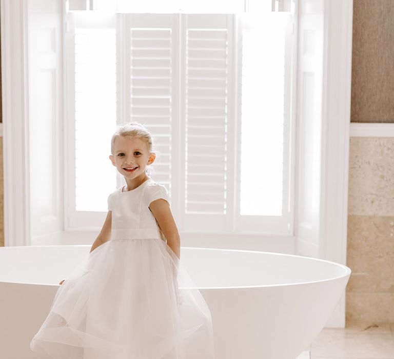 Flower girl in a tulle dress and white trainers at Northbrook Park wedding 