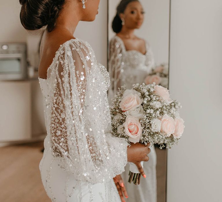 Bride looks into the mirror on her wedding day