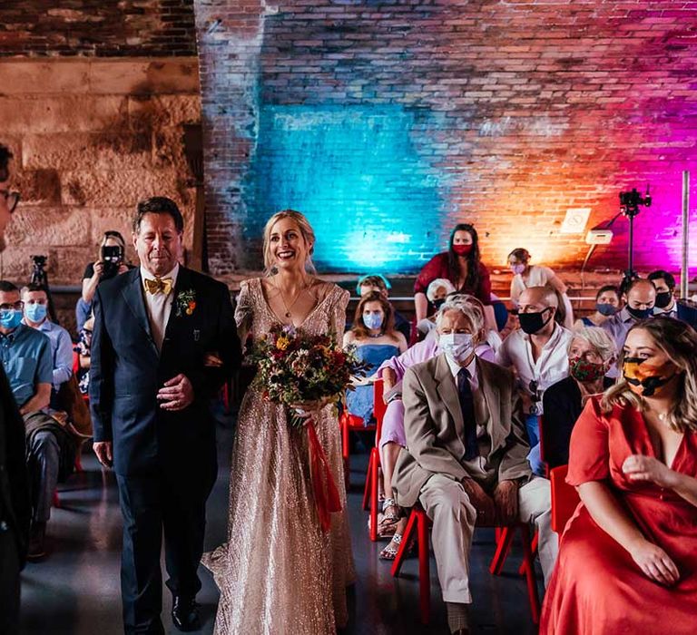 Bride & groom walk through family and friends after evening wedding ceremony