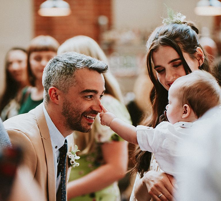 Baby touches wedding guests nose 