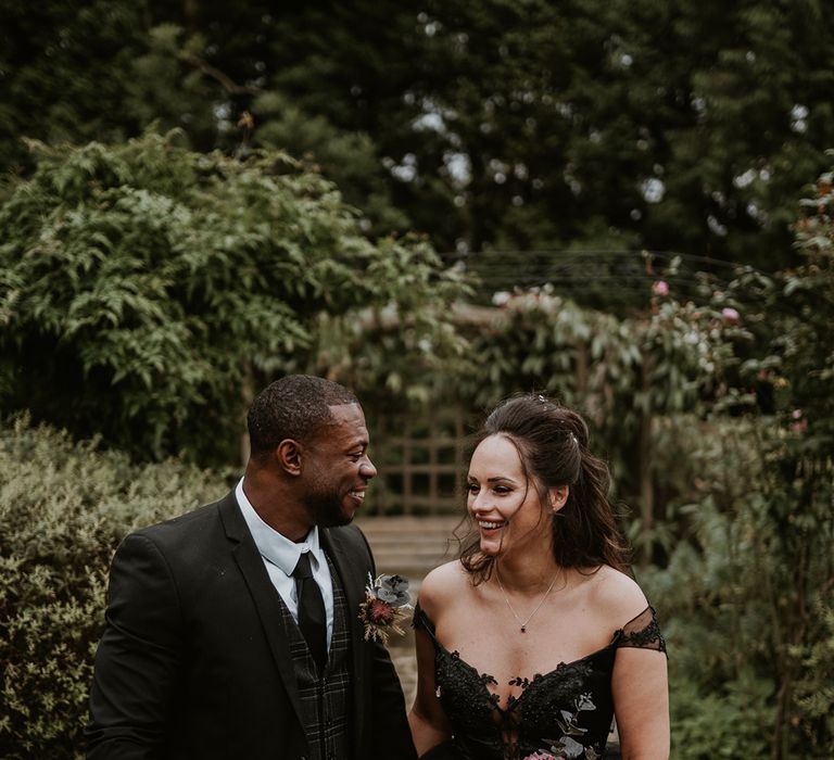 Bride & groom walk hand in hand with one another on their wedding day