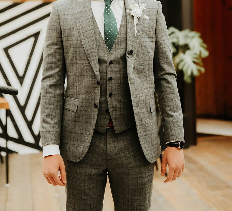 Groom in check suit and green tie for wedding