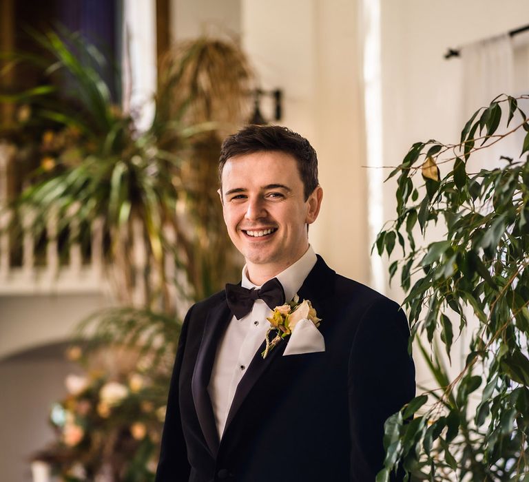 Groom in black tie with toffee rose buttonhole and white handkerchief 