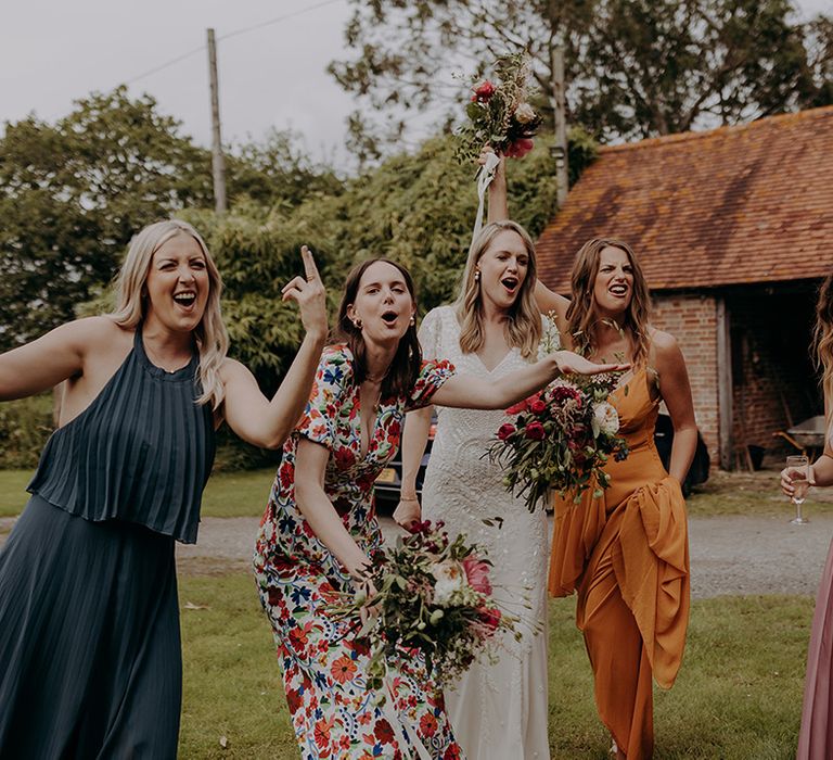 Bride in beaded wedding dress with bridesmaids in a variety of different colours and patterned dresses