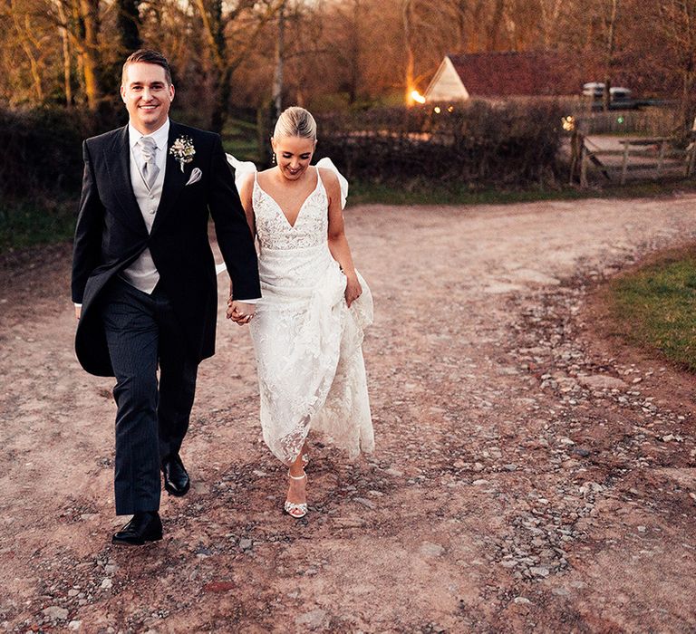 Groom in traditional black and grey morning suit and bride in lace Emmy Mae wedding dress