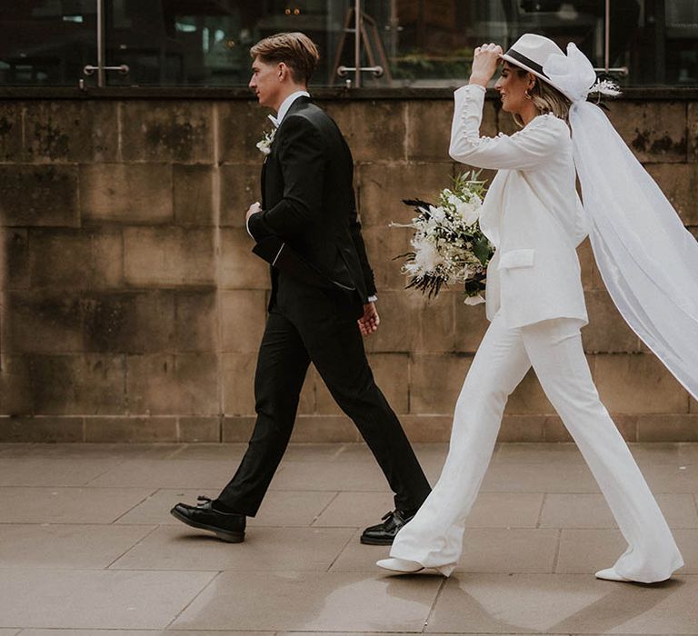 Bride and groom walk together outside their wedding venue 