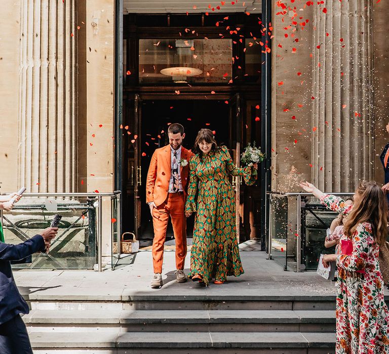 Heart shaped confetti explodes from cannon around bride & groom as they leave Bristol Register Office 