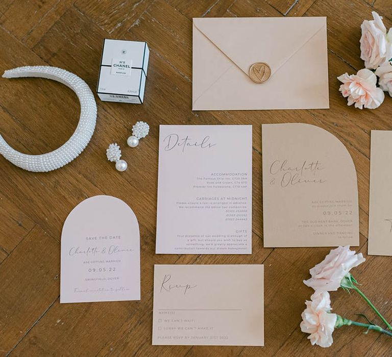 Neutral wedding stationery suite flatlay with gold wax seal by Sweet Ophelia Designs with flowers and bridal accessories 