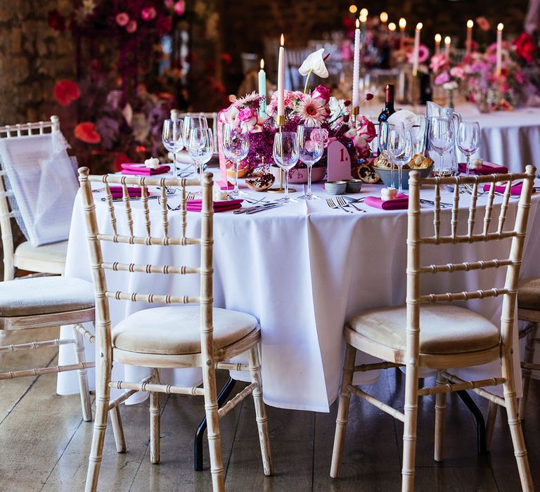 Eco candle wedding favours, bright pink fabric napkins and bright floral centrepiece for modern tablescape look