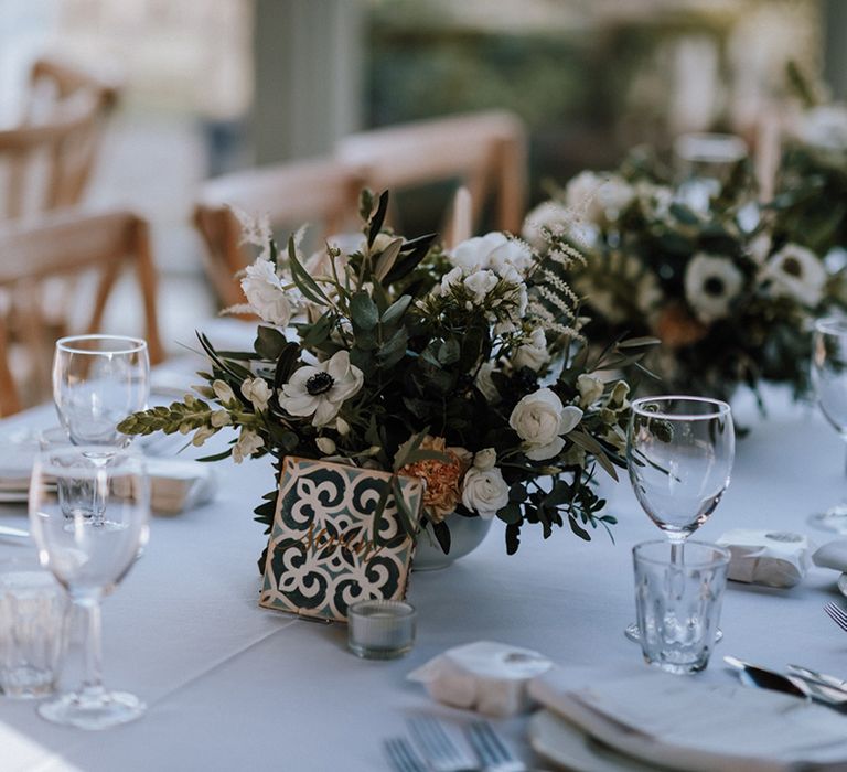 DIY tile table number sign with small floral arrangements