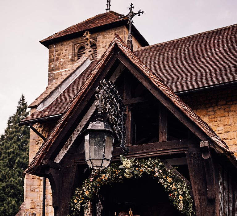 Bride and groom share a kiss at the entrance to the church 