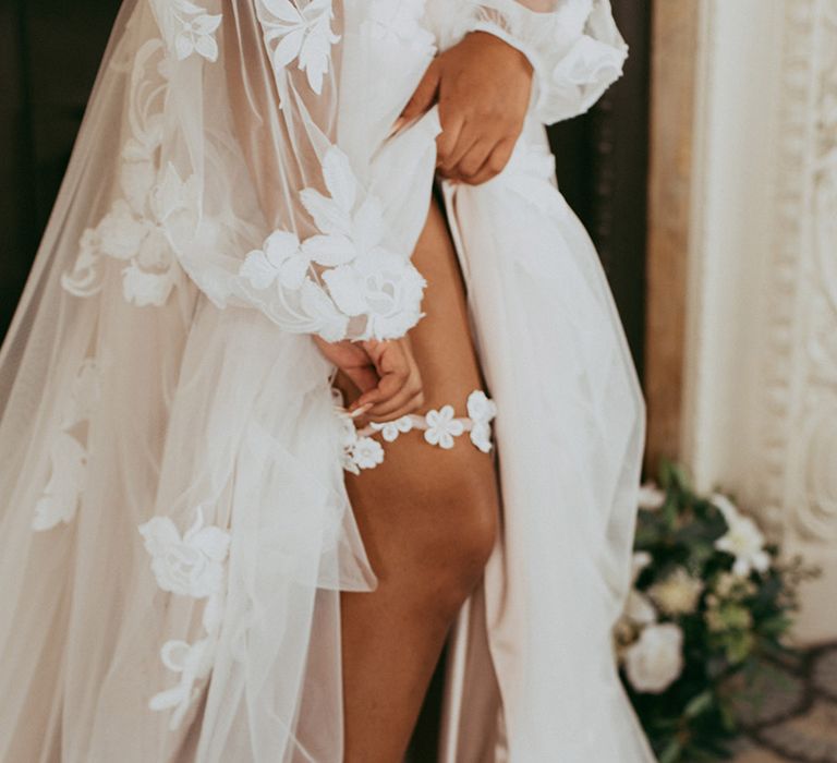 Bride in a sheer puff sleeve floral design wedding dress with a cute floral garter 