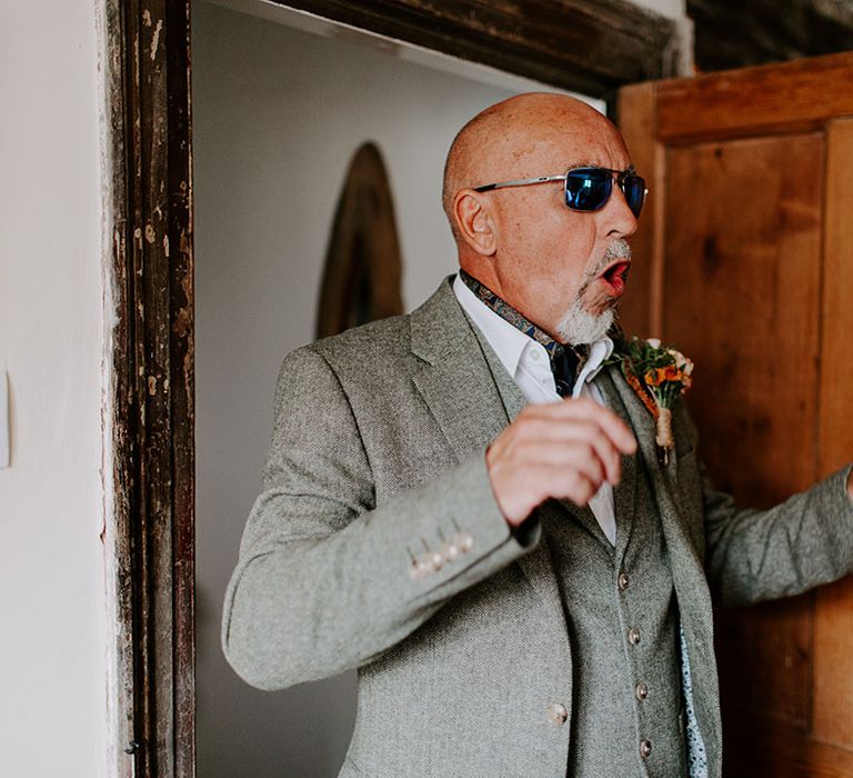 Bride's father sees her for the first time on wedding day wearing sunglasses and grey three-piece suit