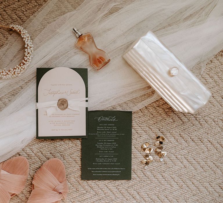 White and green wedding stationery with the bride's pearl headband, perfume, statement earrings, pearlised clutch bag, veil and Loeffler Randall shoes