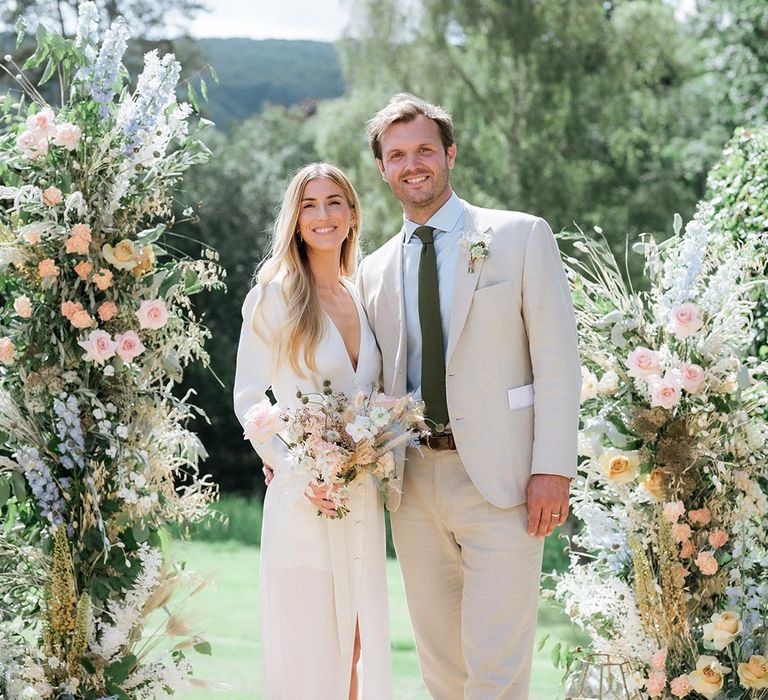 Pastel pink, blue, yellow flower columns for summer outdoor wedding with marquee 