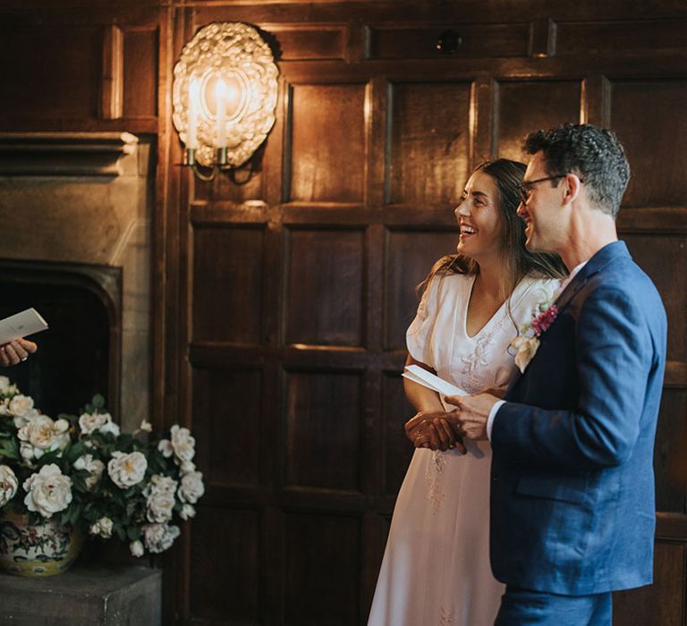 Bride in embroidered wedding dress smiling with the groom in navy suit for humanist and bespoke wedding ceremony 