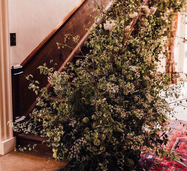 Simple botanical pink and green foliage and greenery decorating the main staircase at Iscoyd Park 