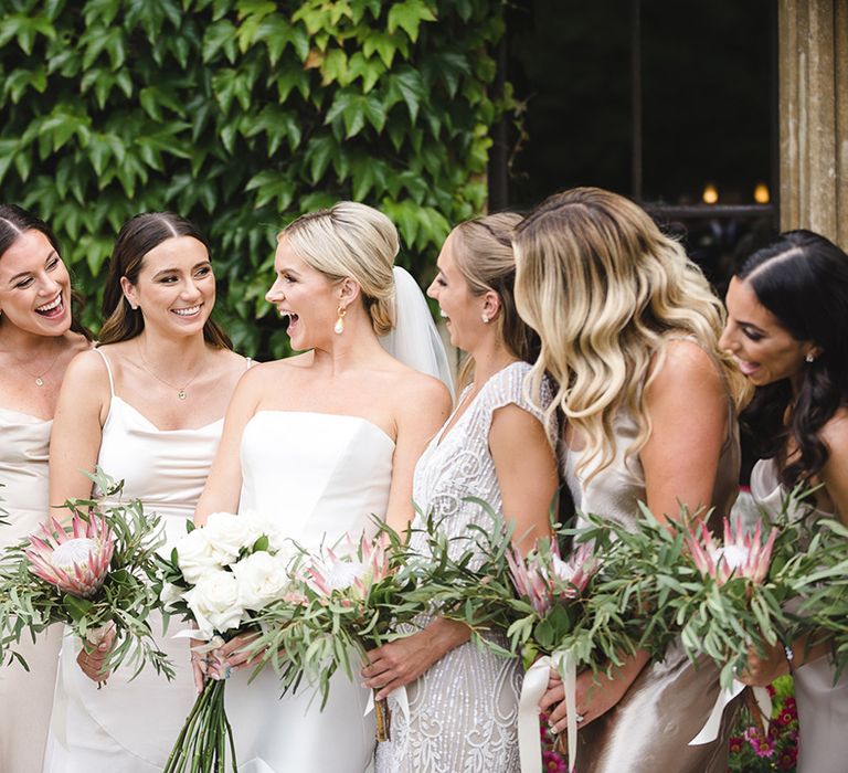 Bridal party with big group of bridesmaids in mismatched gold bridesmaid dresses with the bride 