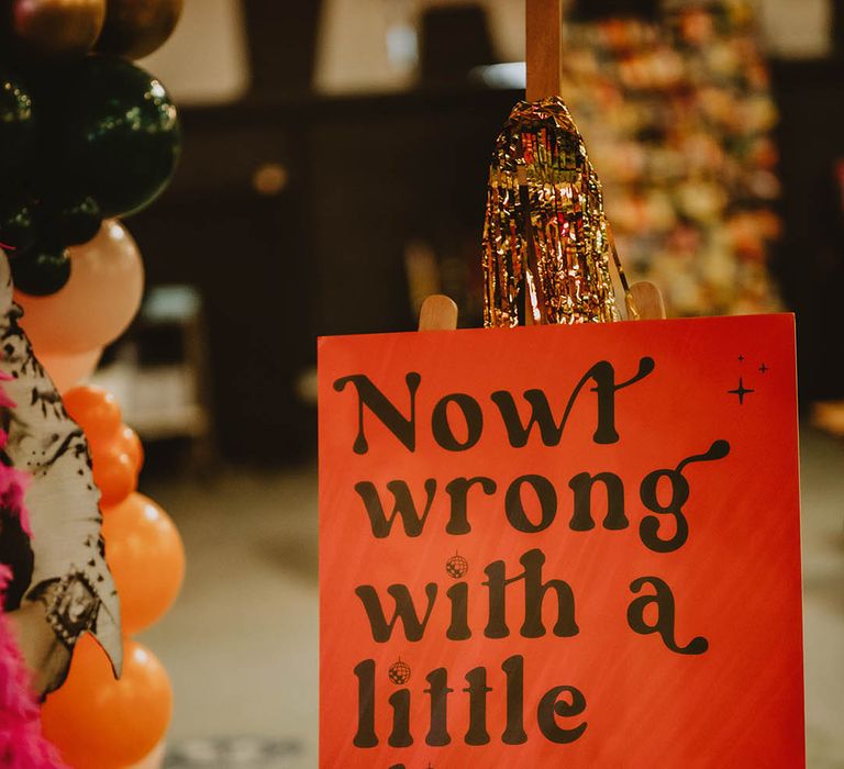 Black and red retro theme wedding welcome sign with Northern slang at vintage 70s-inspired wedding 