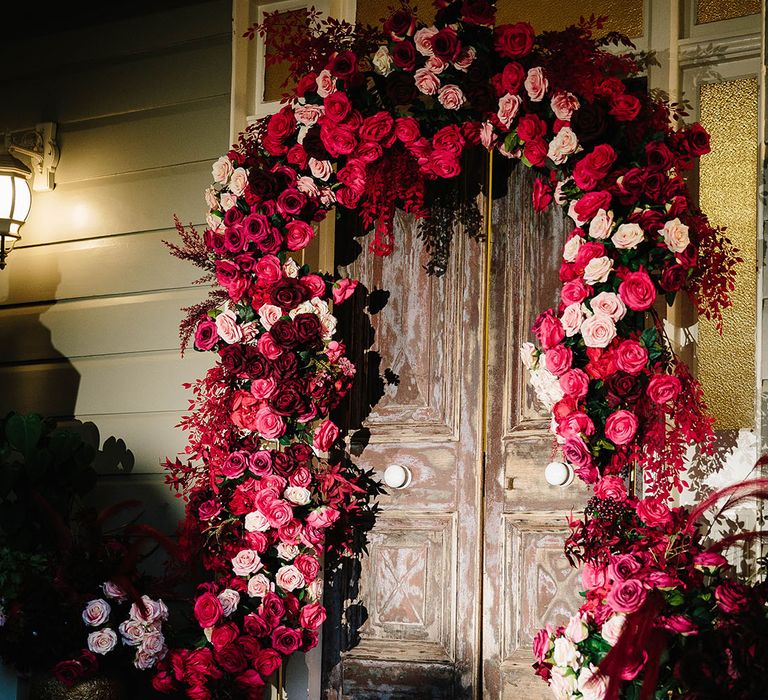 Sri Lankan pink theme wedding with epic dark pink, red and white wedding flower arch decoration 