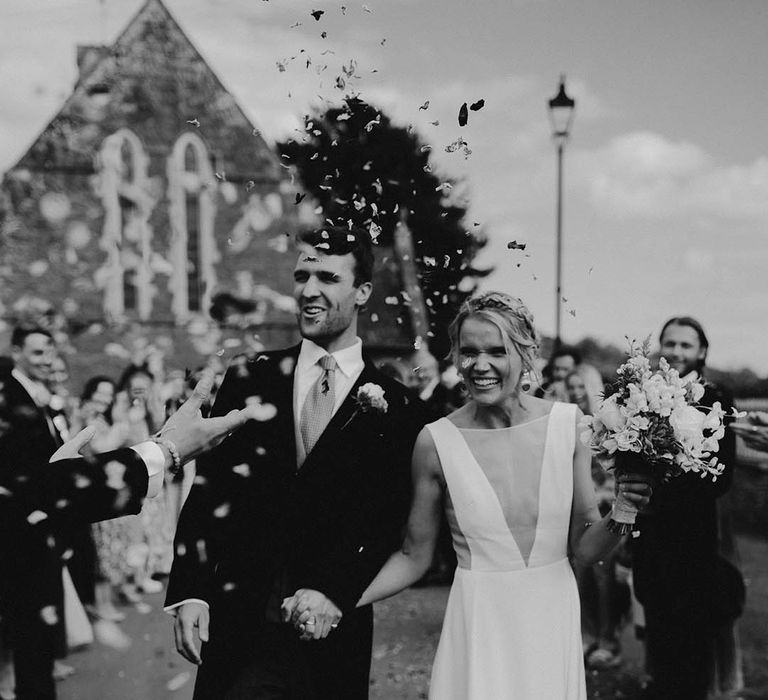 The bride and groom exit from their church ceremony to confetti 