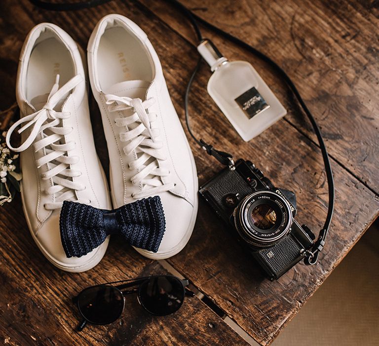 White wedding sneakers from Reiss with gypsophila buttonholes, blue bow tie and camera 