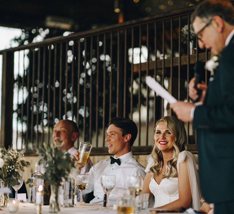 Father of the bride reads out wedding speech to the bride and groom at Stone Barn wedding in the Cotswolds 