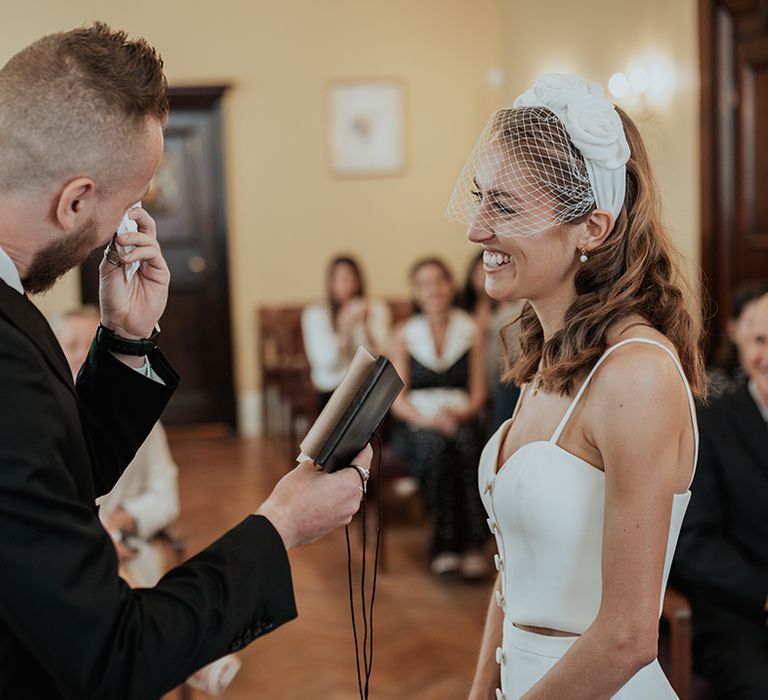 emotional groom in a black suit reading his wedding vows to his bride at their Chelsea Town hall wedding ceremony 