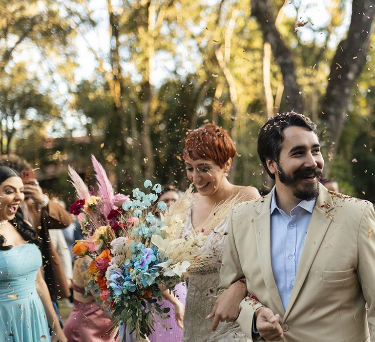 Confetti moment for the bride and groom at their bright and funky wedding 