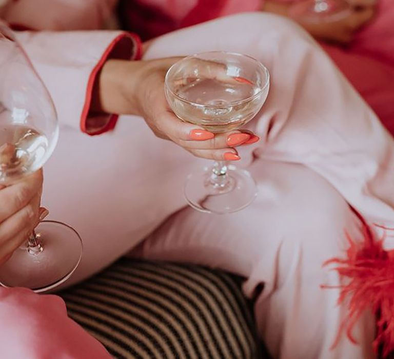 Close up image of bridal party wearing pink pyjamas drinking alcohol 