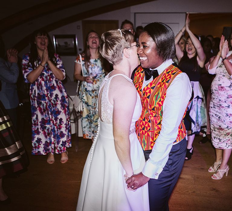 The two brides have their first dance together at wedding reception 