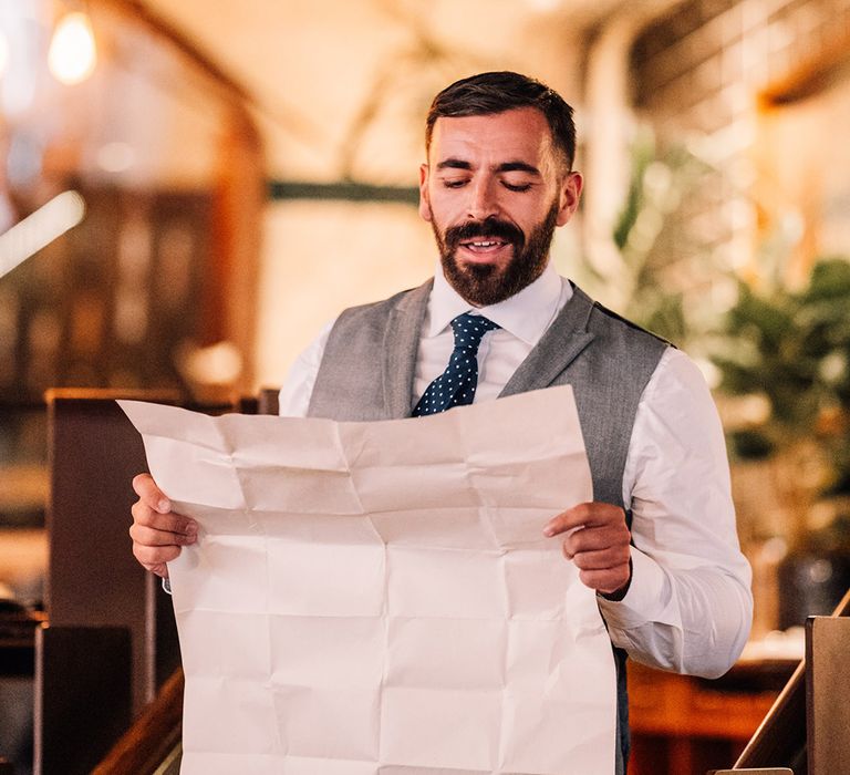 Wedding speech read out by best man from large sheet of paper 