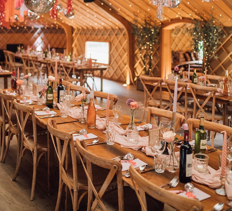 Different shades of pink streamers decorate the roof with disco balls for fun and colourful wedding