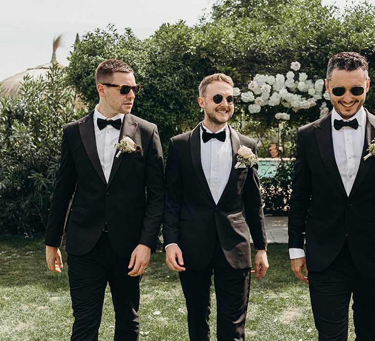 Groom and groomsmen in black tuxedos at traditional Finca Monasterio wedding 