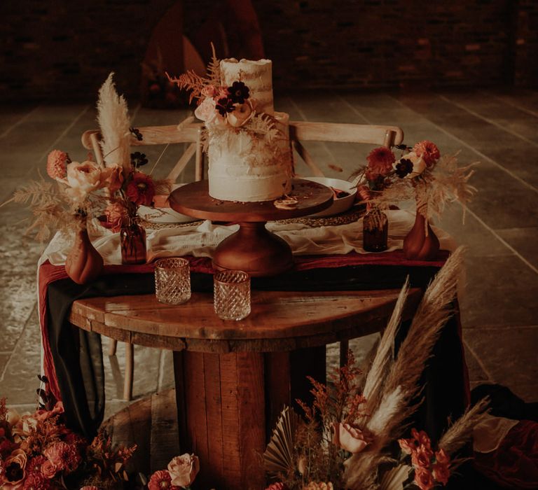 Semi naked wedding cake on a wooden cake stand