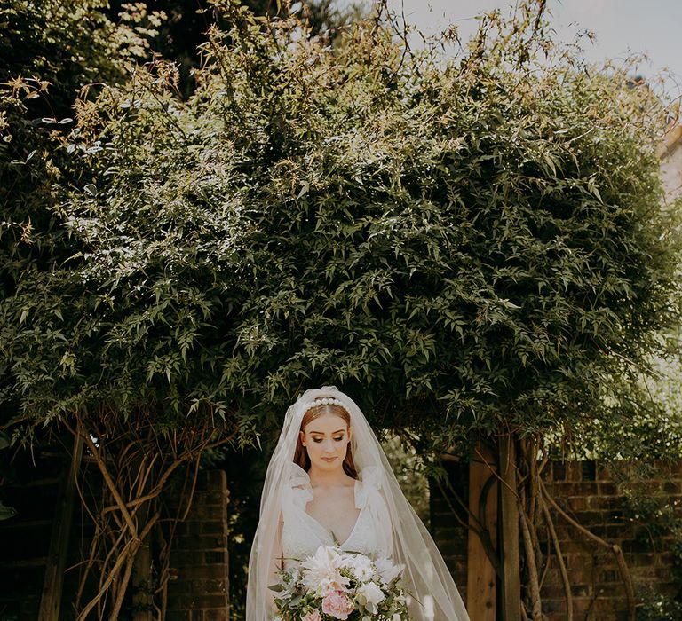 Stylish bride in Inbal Dror wedding dress and cathedral length veil 