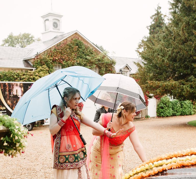 Bridesmaid standing under umbrellas at intimate wedding 