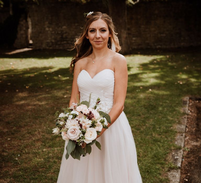 Bride in strapless tulle wedding dress and half up half down wedding hair 