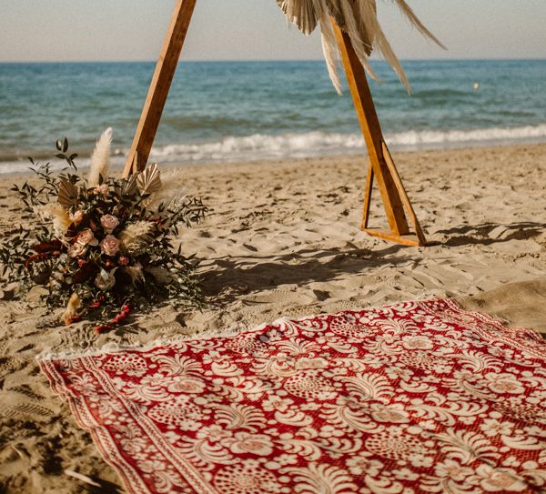 Boho beach wedding in Crete with triangle altar structure and pampas grass decor