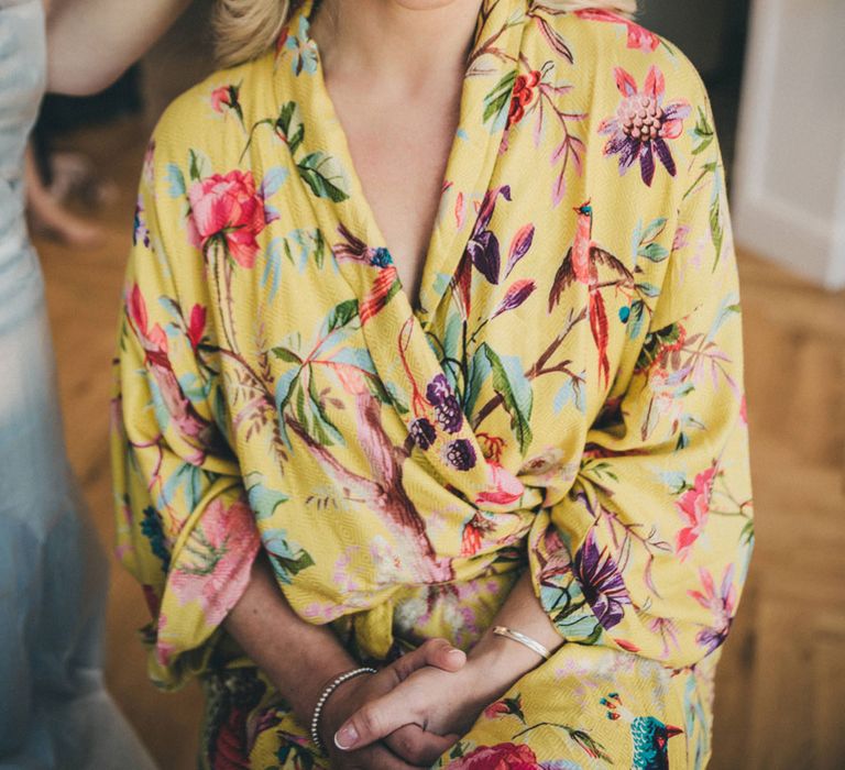 Smiling bride in yellow kimono gets her hair done