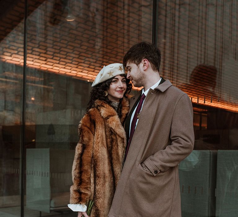 Bride in Mary Benson wedding dress with beret and coat for Winter elopement