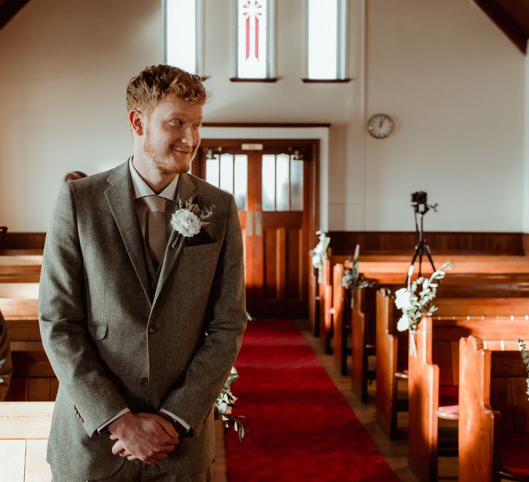 The groom waiting at the church altar