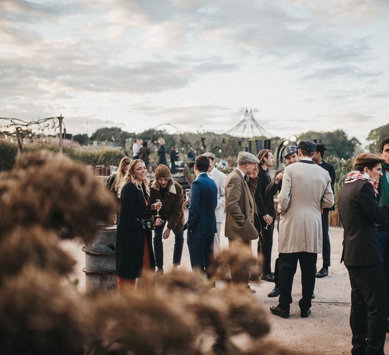 Wedding guests in the courtyard at Les Bonnes Joies wedding venue near Paris, France. 