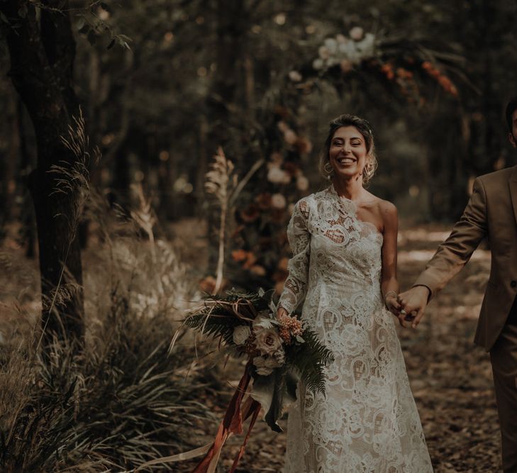 Intimate boho elopement in a forest with a bride in a one shoulder wedding dress