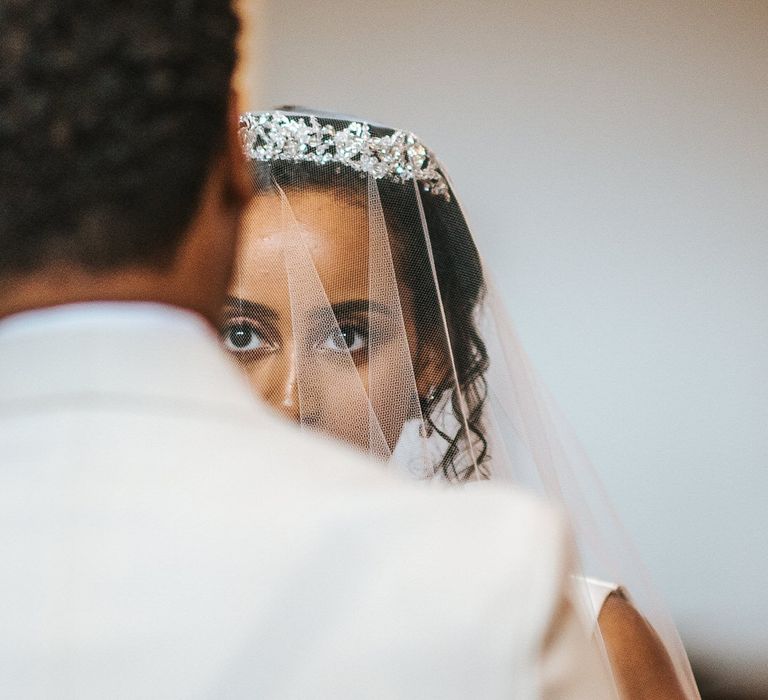 Ethiopian bride in a tiara and veil looking at her groom 