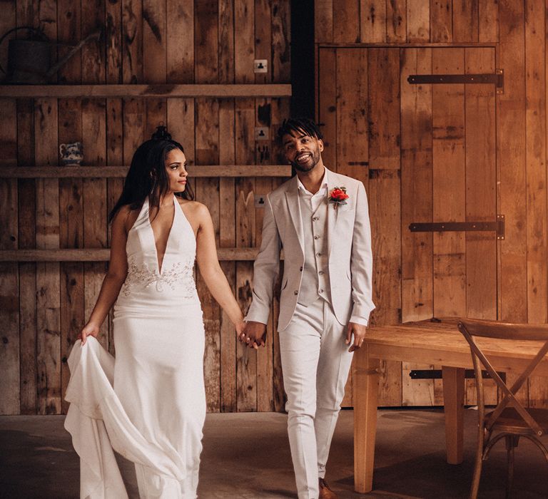 Bride & groom hold hands and walk together 