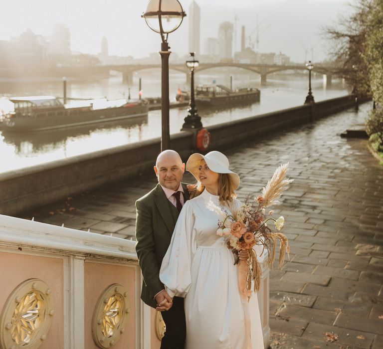 Bride & groom stand together on their wedding day outdoors