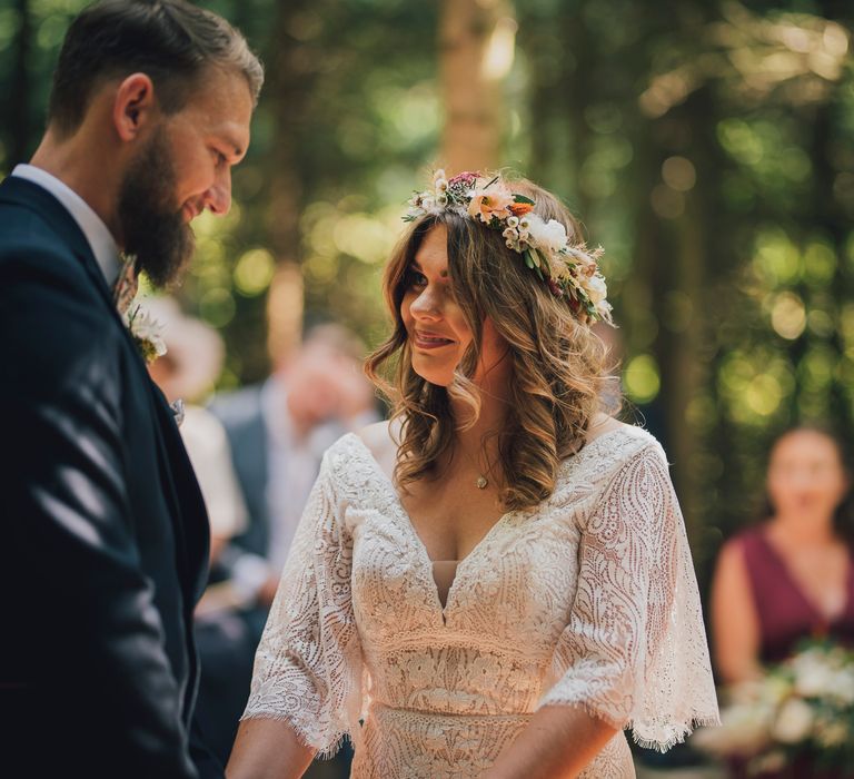 Bride wears flower crown and boho chic wedding gown from Enzoani 