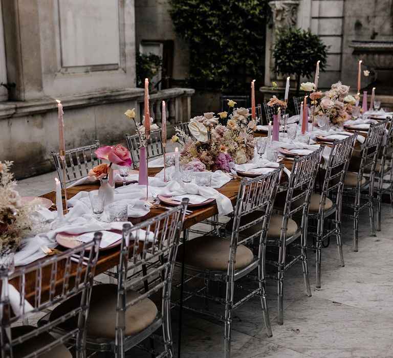 Intimate tablescape with pink taper candles and floral centrepiece table decor 