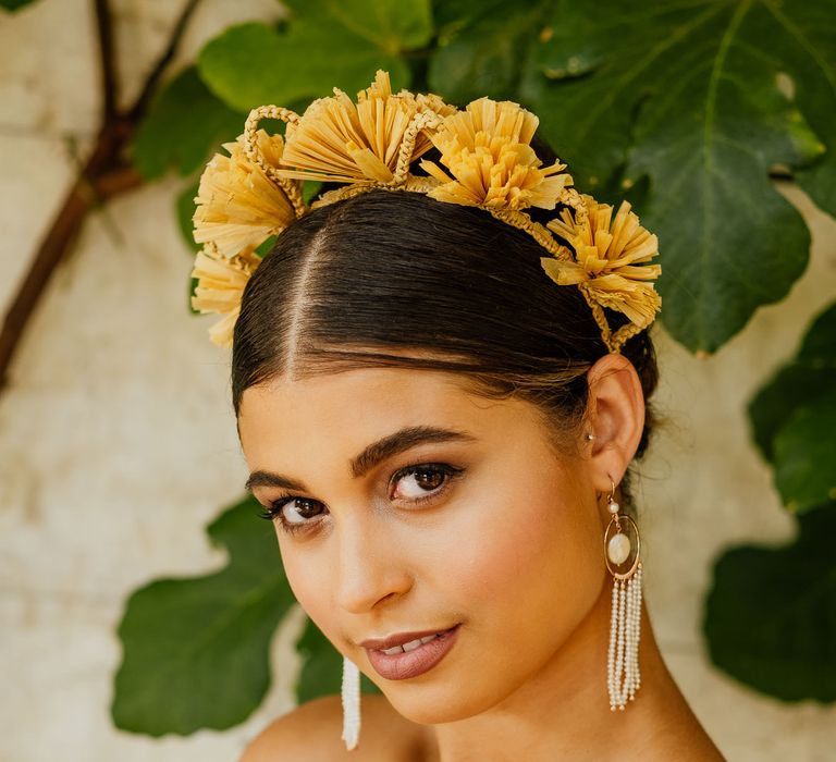 Bride in a strapless wedding dress with tassel earrings and yellow flower headband for fiesta theme wedding